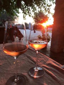 巴莱Farmhouse Cubani的两杯酒坐在桌子上,欣赏日落美景
