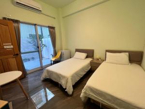 兴达港民宿的客房设有两张床、一张桌子和一扇窗户。