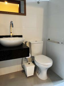 沙帕达-杜斯吉马朗伊斯Pousada La Belle de Jour的浴室配有白色卫生间和盥洗盆。