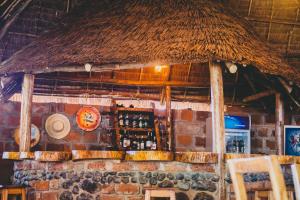 莫希Kilimanjaro Scenic Lodge的一间有稻草屋顶和砖墙的酒吧