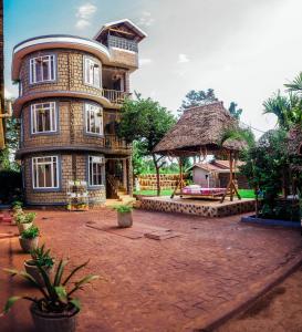 莫希Kilimanjaro Scenic Lodge的一座大型砖砌建筑,前面有一个大院子