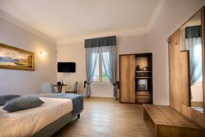博洛尼亚D'AZEGLIO 62 LUXURY ROOMS的一间卧室配有一张床、一张书桌和一个窗户。