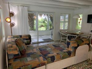 弗拉格勒海滩Oleander Cottage- in the Heart of Flagler Beach and steps to the Beach!的一间卧室设有一张床和一间客厅。