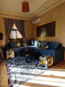 泰赫瑙特ApartHotel Nzaha的客厅配有蓝色的沙发和椅子