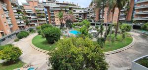 罗马Home-like Apartment的公寓大楼设有带游泳池和树木的庭院。