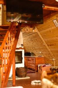 CărbuneştiCatunu’ lui Emil的小屋内的厨房设有楼梯和电视