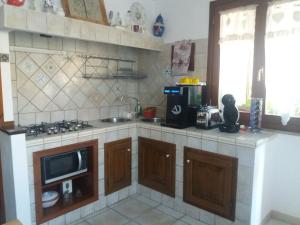 萨萨里I Due Ciuchini Sardinia的厨房配有水槽、炉灶和微波炉
