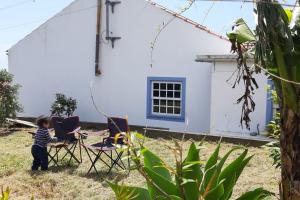 Lajes das FloresA Barraka: your cozy house in Flores!的站在房子前面的院子中的孩子