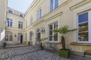 昂热Maison Bossoreil - Chambre Layon的庭院里一座棕榈树的大建筑