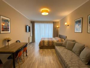古多里New Gudauri Alpen Apartments的酒店客房配有床、沙发和桌子。