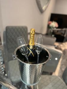 斯凯格内斯The Penthouse - Luxury 2 Bed Apartment的桶装一瓶香槟和两杯葡萄酒
