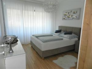 林茨Ferienwohnung DANUBIA的一间白色客房内的床铺卧室