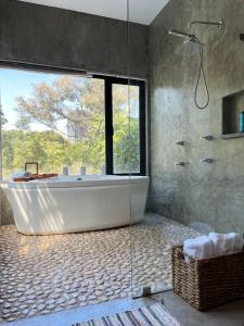 墨西哥城Mi Refugio San Angel的带浴缸的浴室和大窗户