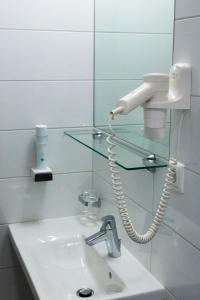 奥滕斯海姆维诺泰克斯华泽尔酒店的一间带水槽的浴室和镜子上的电话