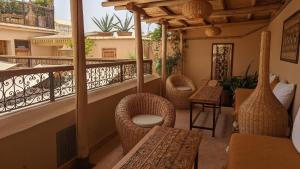 马拉喀什Riad Dar Eternity的阳台配有藤椅和桌子。