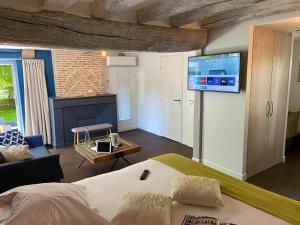 Candé-sur-BeuvronAuberge de la Caillère - Teritoria的一间卧室配有一张床,墙上配有电视