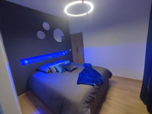 瓦龙Cocon Lux au centre de Voiron的一间卧室配有一张蓝色灯床