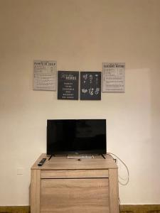 GhediCasa Andrea的墙上挂有标志的梳妆台上方的电视