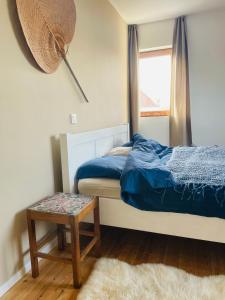 科克赛德Zeehuis的一间卧室设有床、窗户和凳子
