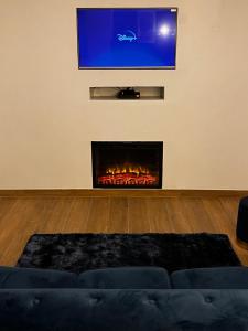Triel-sur-SeineBulle Evasion的客厅设有壁炉,墙上配有电视。