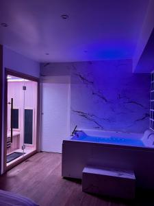 Triel-sur-SeineBulle Evasion的大型浴室设有紫色照明浴缸