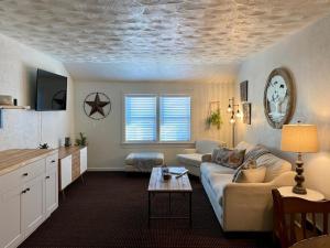 科迪Moose Creek Lodge & Suites的客厅配有沙发和桌子