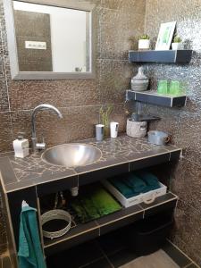 PoponguineAfrican Jaja villa Piscine-Climatisation的浴室的柜台设有水槽和镜子