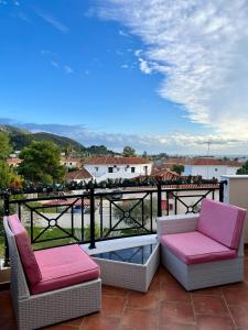 卡拉马孔Anagenessis Resort的阳台配有两把椅子和一张茶几