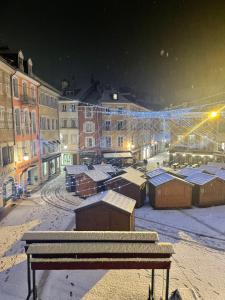 加普L’appart chic gapençais的夜晚带长凳的白雪 ⁇ 的城市景观