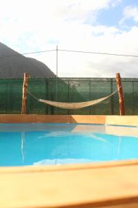 奥克萨潘帕Cabaña Alpina SEAL的一个带吊床和围栏的游泳池
