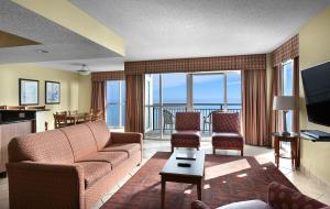 默特尔比奇美特尔海滩海湾景度假酒店的客厅配有沙发、椅子和电视
