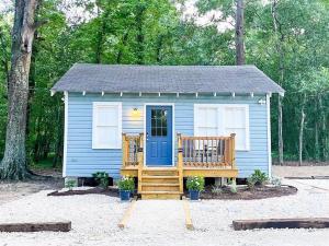 拉斐特Unwind & Relax at Azalea Cottage on Bayou的蓝色的小房子,设有门廊和蓝色的门