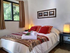 拉佩德雷拉Aloha Village的一间卧室配有一张带红色枕头的大床