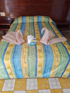 韦拉克鲁斯Hotel Verasol的床上配有毛巾和拖鞋
