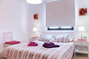 阿雷西费Enjoy Arrecife Center的一间卧室配有一张带紫色枕头的床