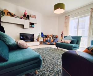 马萨尔福恩Fur, Purr & Pool的客厅配有2张蓝色沙发和电视