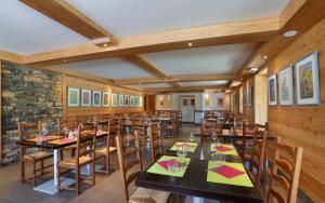 MieussyLes Roches 1500的餐厅拥有木墙和桌椅