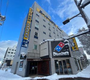 青森Super Hotel Aomori的多米诺酒店在雪中 ⁇ 染