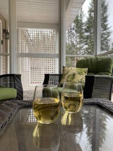 亨茨维尔Modern 4 season cottage retreat的玻璃桌旁放两杯葡萄酒