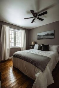 亨茨维尔Modern 4 season cottage retreat的一间卧室配有一张带吊扇的床