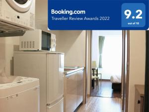 那霸Best ever hotel -SEVEN Hotels and Resorts-的厨房配有冰箱和微波炉。