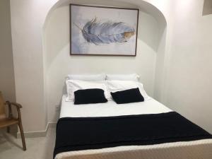 萨尔瓦多TURISHOUSE SUITES的一张白色的床,上面有两个枕头