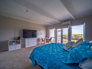 史密斯海滩1-bedroom unit with balcony and ocean views!的一间卧室设有蓝色的床和一个阳台