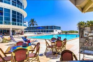 迈阿密海滩7th - 7 Heaven Miami - Stunning Ocean View - Free Parking的一座带桌椅的游泳池以及一座建筑
