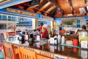 迈阿密海滩7th - 7 Heaven Miami - Stunning Ocean View - Free Parking的一间设有酒吧的餐厅,有人站在柜台旁