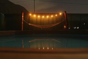 奥克萨潘帕Cabaña Alpina SEAL的夜间带灯光的围栏和游泳池