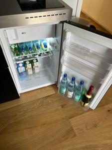科隆Köln City Stillvolle Apartment的配有瓶装水和饮料的开放式冰箱