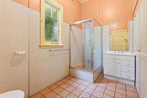 纳鲁马The Seamist Cottage的带淋浴、盥洗盆和卫生间的浴室
