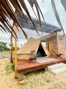 佩纳利克村Rembulan Escape - beachfront bell tent (no 1)的房屋前带木甲板的帐篷