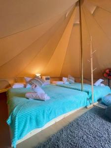 佩纳利克村Rembulan Escape - beachfront bell tent (no 1)的一间帐篷内带两张床的卧室